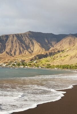 The Beach of Tarrafal de Monte Trigo in Santo Antão is a tranquil paradise with black volcanic sands, crystal-clear waters, and breathtaking mountain views.