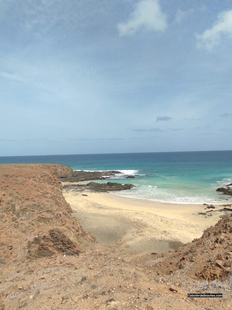 Ribeira Dom João Beach on Maio Island, Cape Verde – sweeping view of white and black sand, clear waters, and untouched natural surroundings under blue sky.