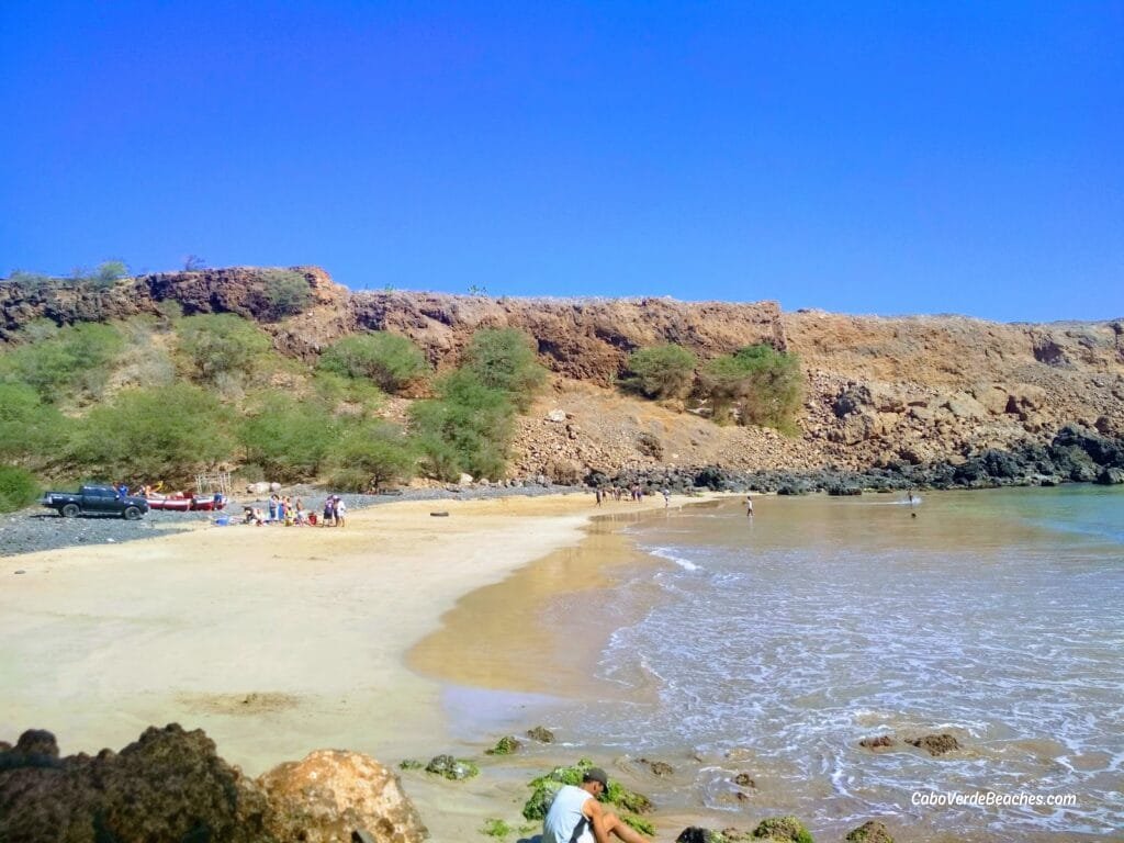 Picturesque Portinho Beach on Santiago Island, showcasing its golden sands, turquoise waters, and the surrounding mountainous terrain.