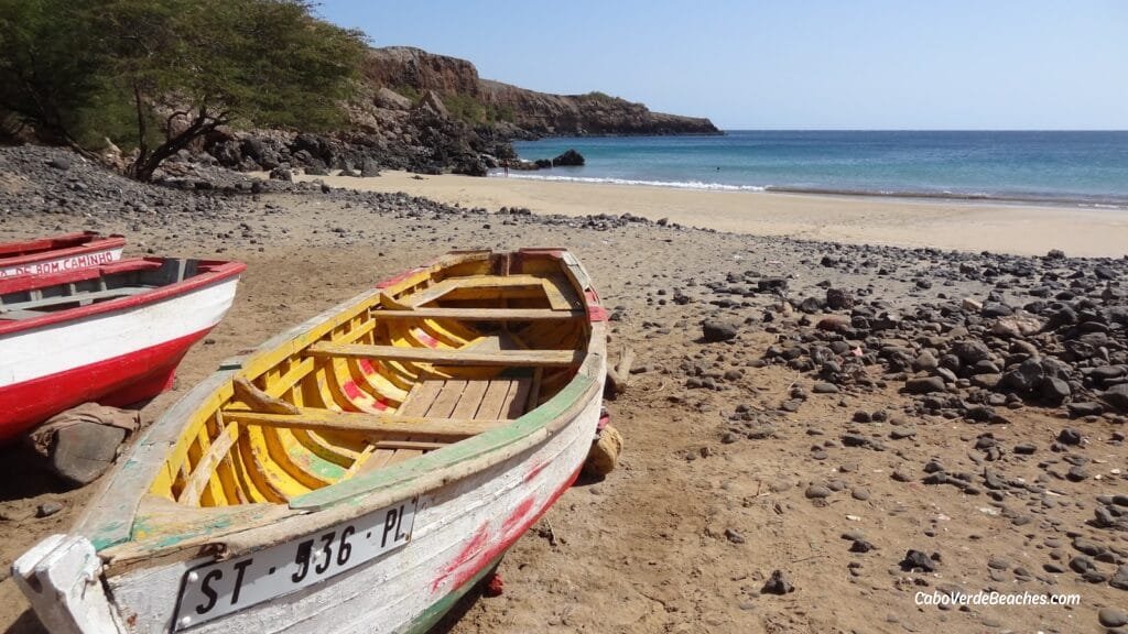 Picturesque Portinho Beach on Santiago Island, showcasing its golden sands, turquoise waters, and the surrounding mountainous terrain.