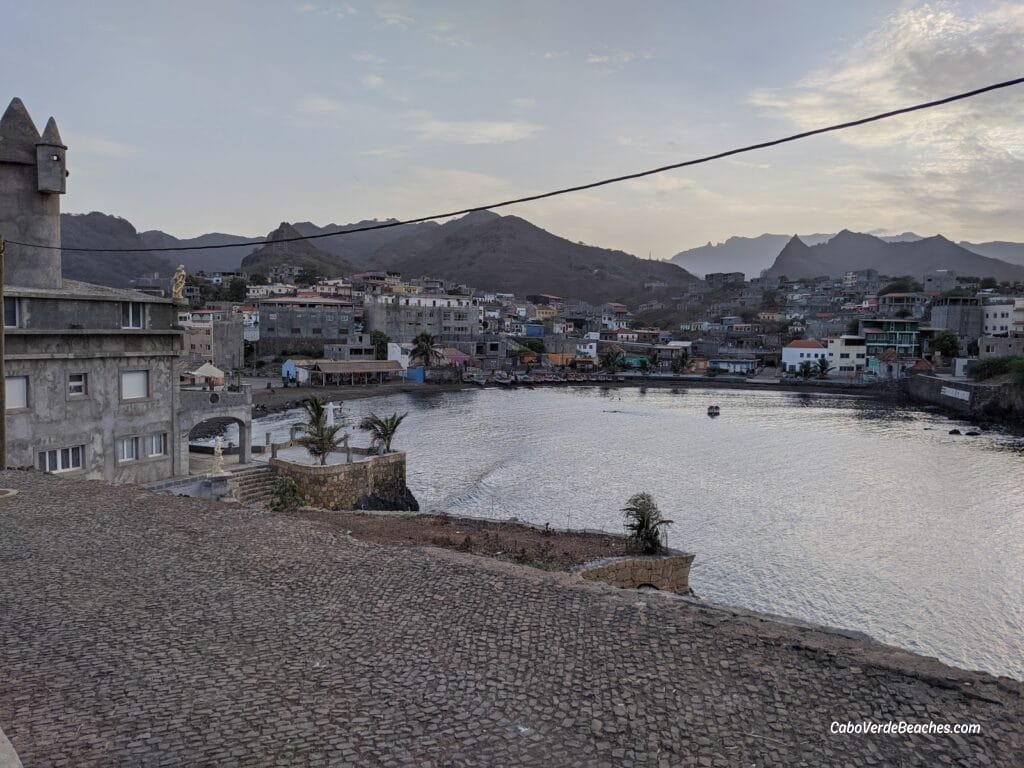 Golden sands and turquoise waters of Porto Calheta Beach, with traditional fishing boats anchored nearby in Santiago, Cape Verde.