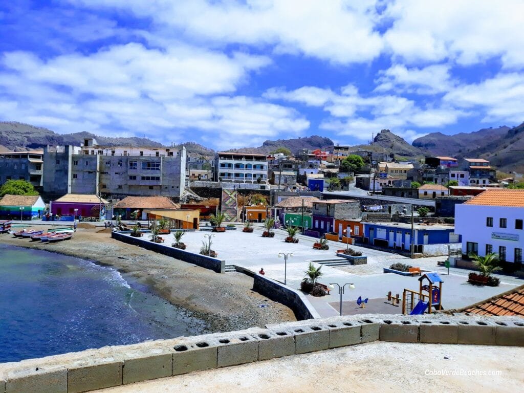 Golden sands and turquoise waters of Porto Calheta Beach, with traditional fishing boats anchored nearby in Santiago, Cape Verde.