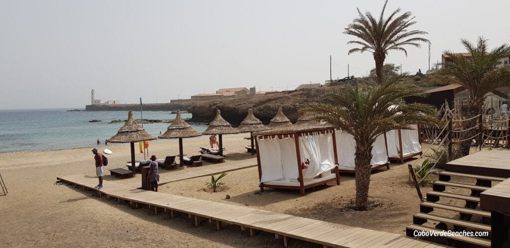 Golden sands and turquoise waters at Prainha Beach, framed by cliffs and lush vegetation on Santiago Island, Cape Verde.
