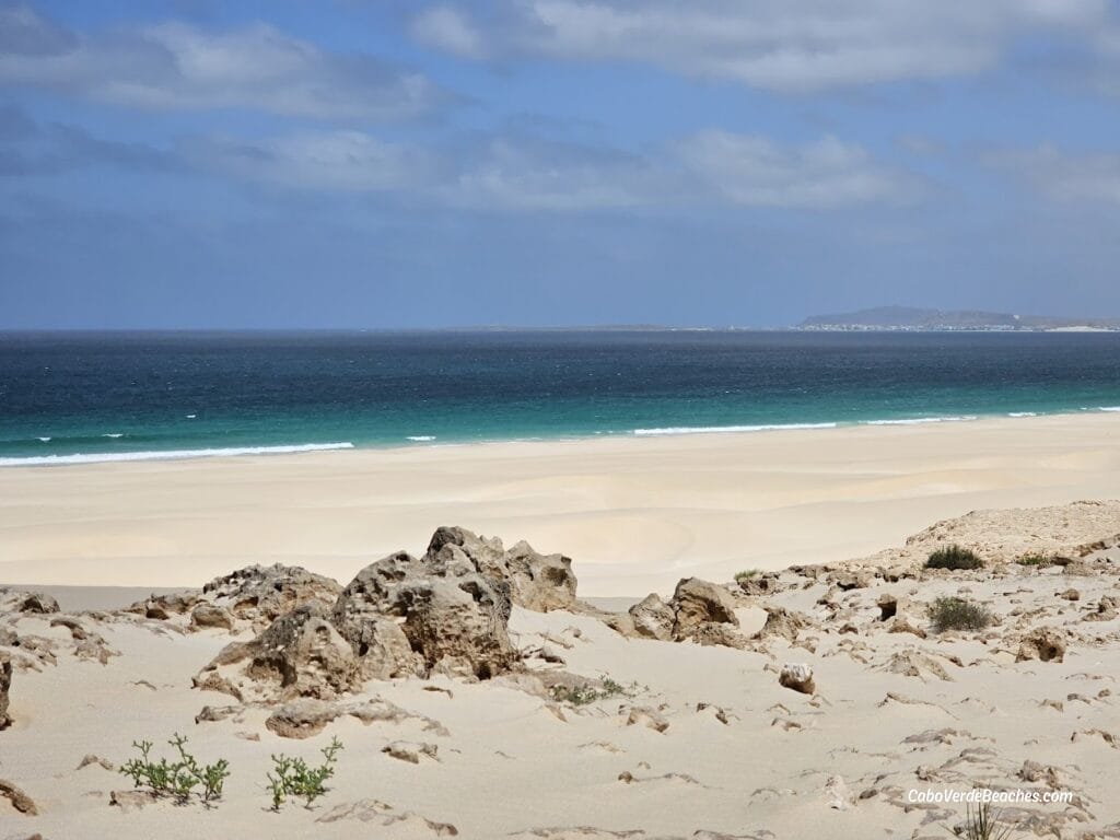 Golden dunes of Morro de Areia cascade into turquoise Atlantic waters beneath a 167 m sand hill, where Boa Vista’s desert meets the ocean in tranquil, protected beauty.