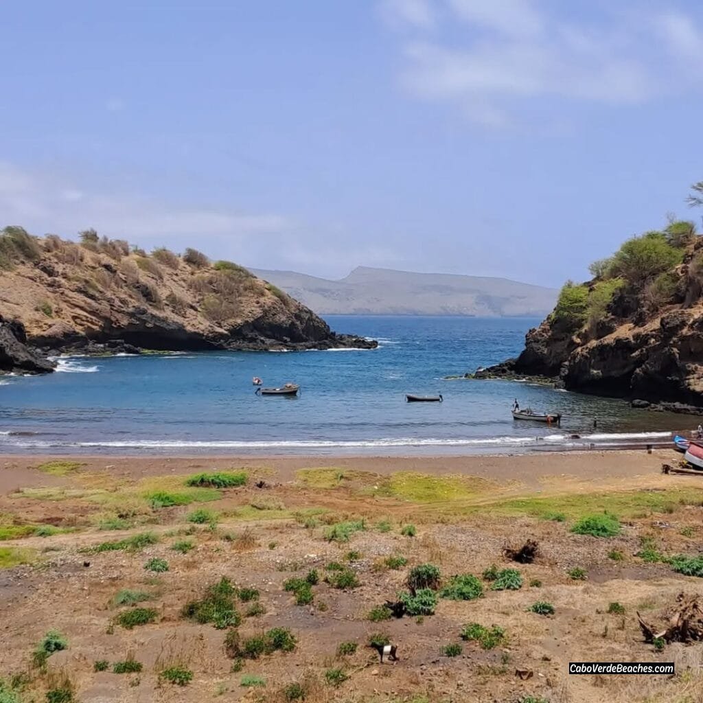 A panoramic view of Porto Formoso Beach, showcasing its pristine sandy cove nestled between rugged cliffs and the turquoise waters of the Atlantic Ocean.​
