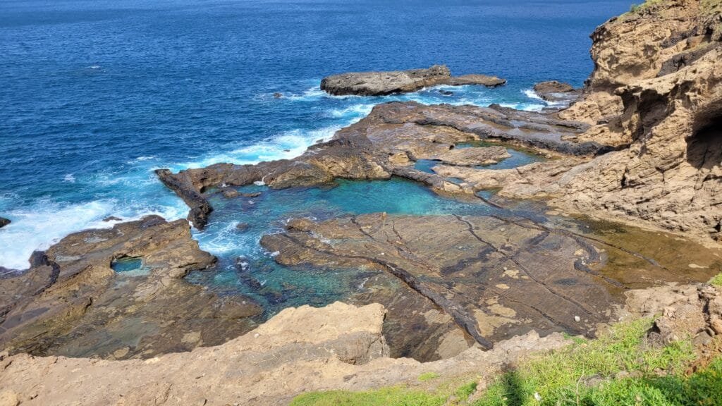A breathtaking view of Piscina Natural Faja De Agua in Cape Verde, with turquoise waters surrounded by dark volcanic rocks.