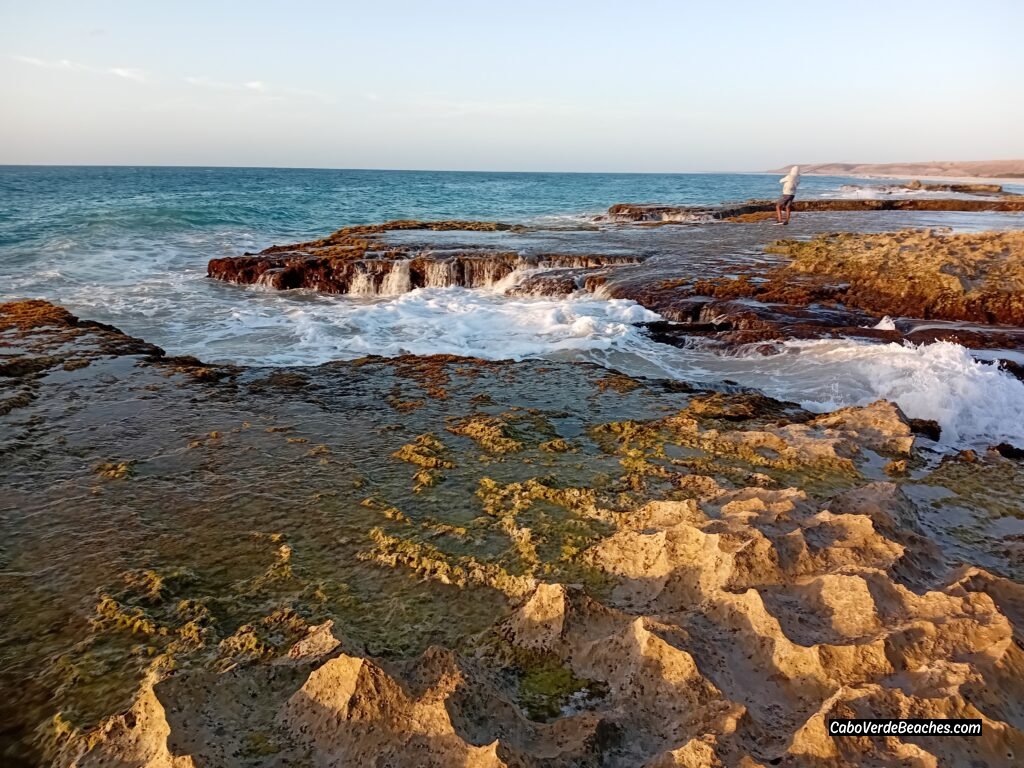 Wild coastal landscape at Ervatão Beach in Cabo Verde featuring dramatic waves and natural rocky formations.